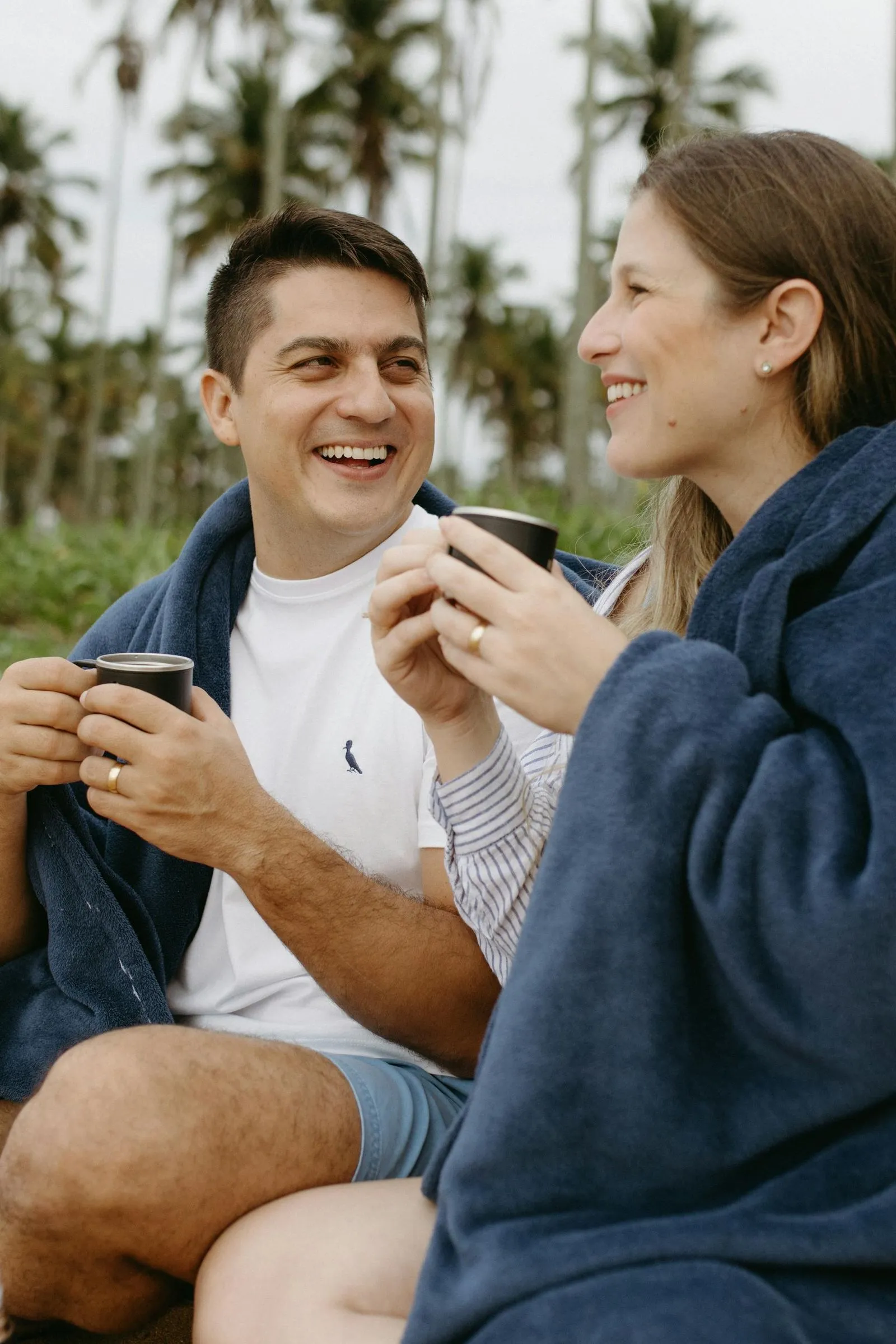 A man and a woman sitting on a beach.